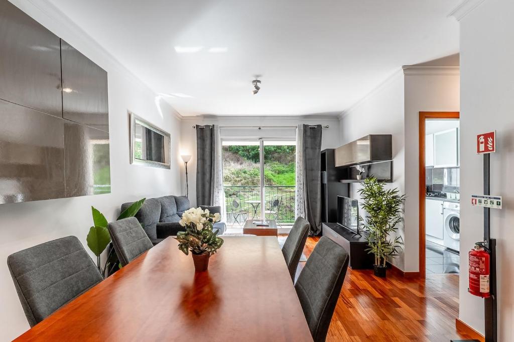 ein Wohnzimmer mit Esstisch und Couch in der Unterkunft Brisa do Caniço in Caniço