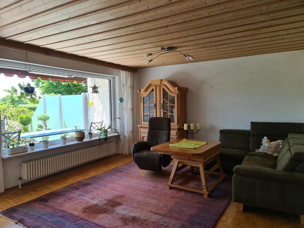 Una sala de estar con un sofá y una mesa y una ventana. en La Datcha, en Unterschleißheim