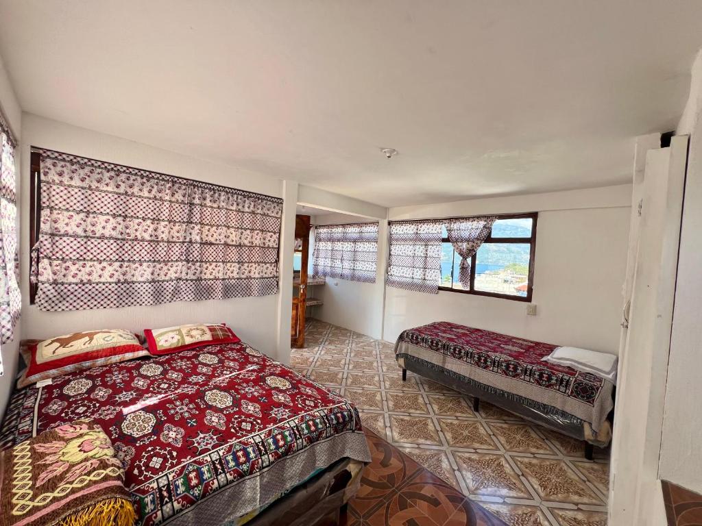 ein Schlafzimmer mit einem Bett und einem Fenster in der Unterkunft Hotel Henderson in San Pedro La Laguna