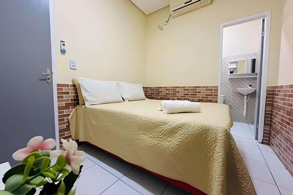 - une petite chambre avec un lit et une salle de bains dans l'établissement Pousada Caminho das Águas, à Santo Amaro