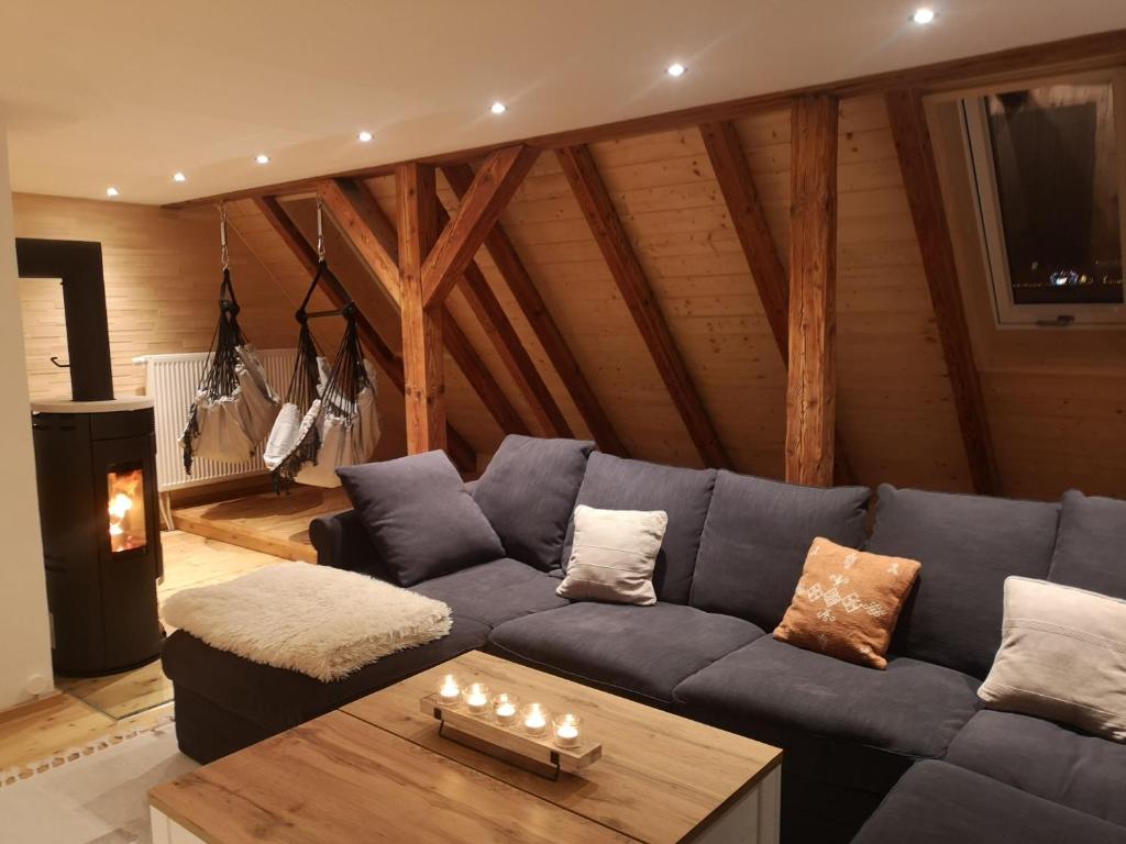 un salon avec un canapé bleu et une table dans l'établissement Moderne Ferienwohnung Mit Hot Tub Und Fasssauna, à Hohenberg an der Eger