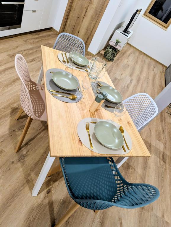 un tavolo di legno con piatti e bicchieri sopra di Le Douillet 20' Strasbourg logement neuf CLIM a Marlenheim