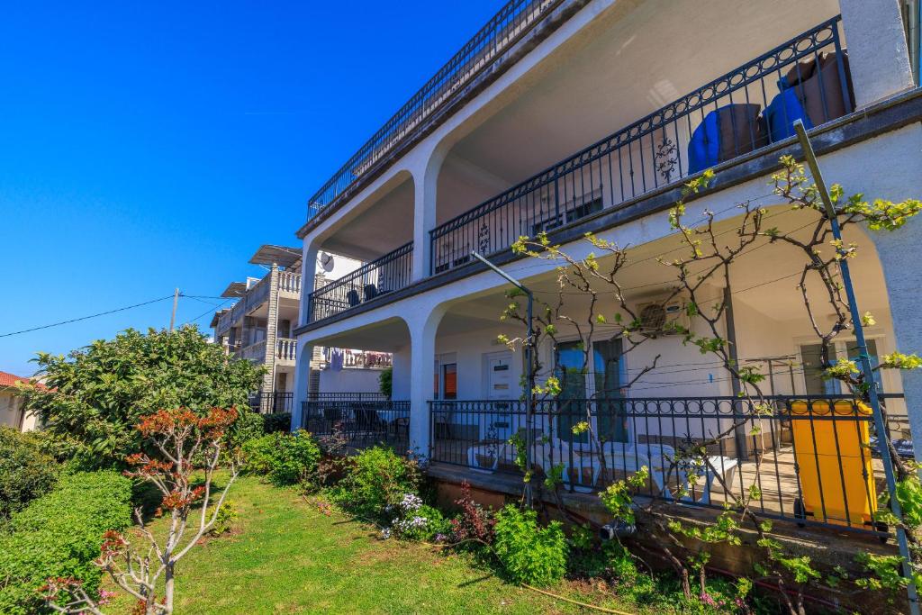 an apartment building with a balcony and a yard at Apartments Marija in Senj