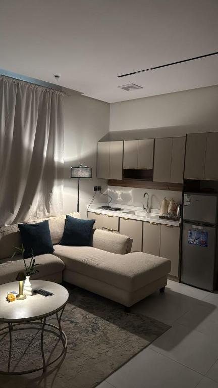 un soggiorno con divano e cucina di شقة الفيصلية a Gedda