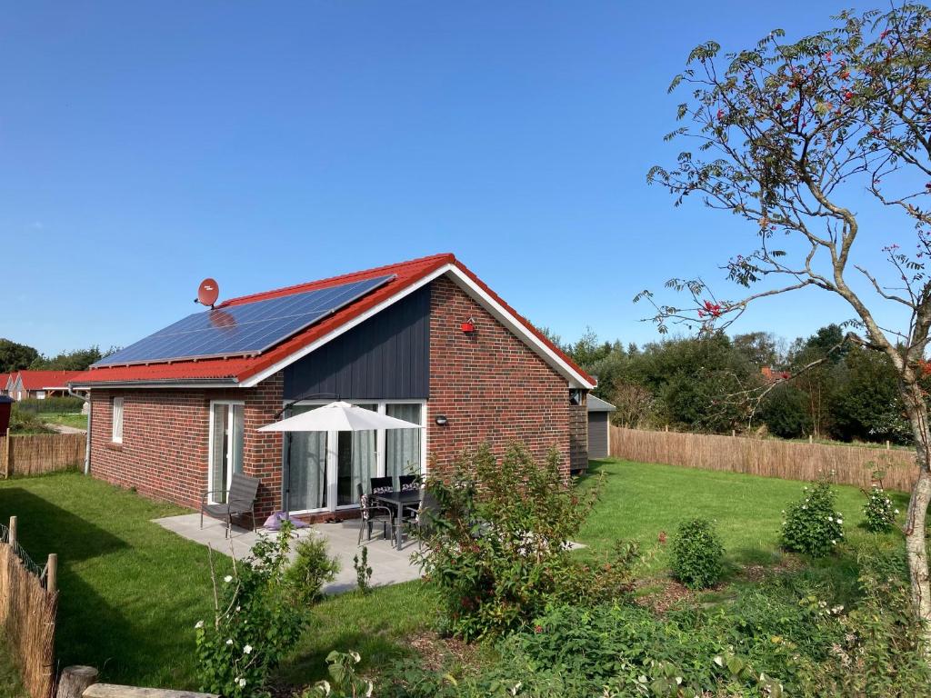 a brick house with a solar roof in a garden at Ferienhaus In Sehestedt Mit Garten in Sehestedt