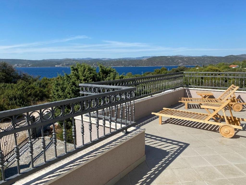 a balcony with two benches and a view of the water at Gemütliches Haus In Drvenik Mali Mit Meerblick in Dolići