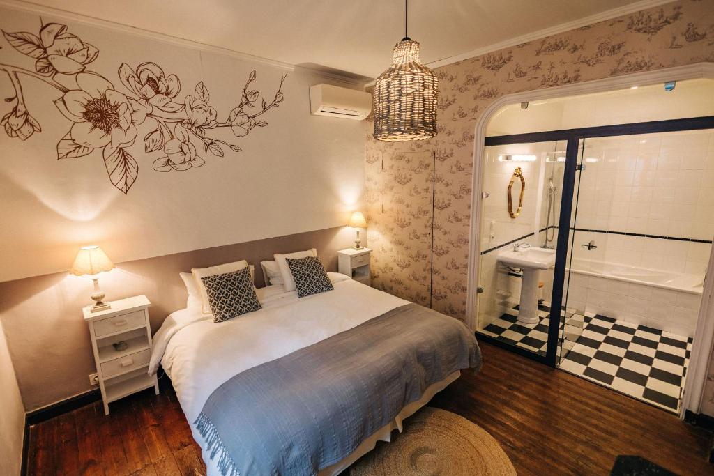 a bedroom with a bed and a bathroom with a tub at Chambre d'hôtes tout confort proche Collioure Côté Saisons in Laroque-des-Albères