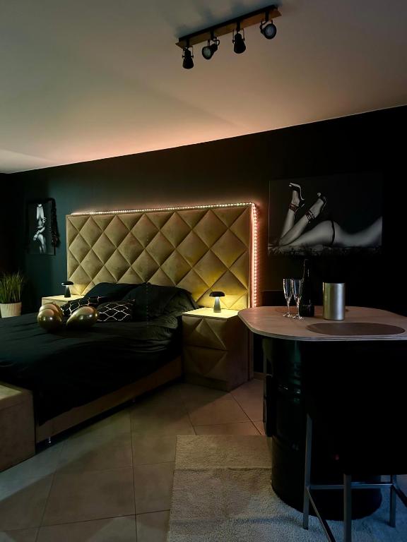 a bedroom with a bed with a headboard and a table at La cachette de Georgette in Landrecies