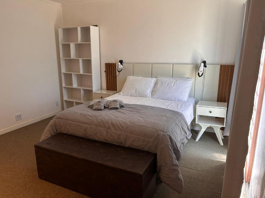 une chambre avec un lit sur lequel est assis un chat dans l'établissement Andradas House - Casa em Uruguaiana, à Uruguaiana