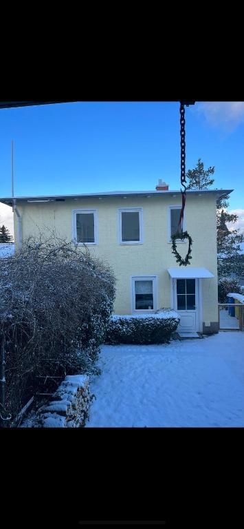 a white house with snow in front of it at Ferienwohnung Odessa in Zinnowitz