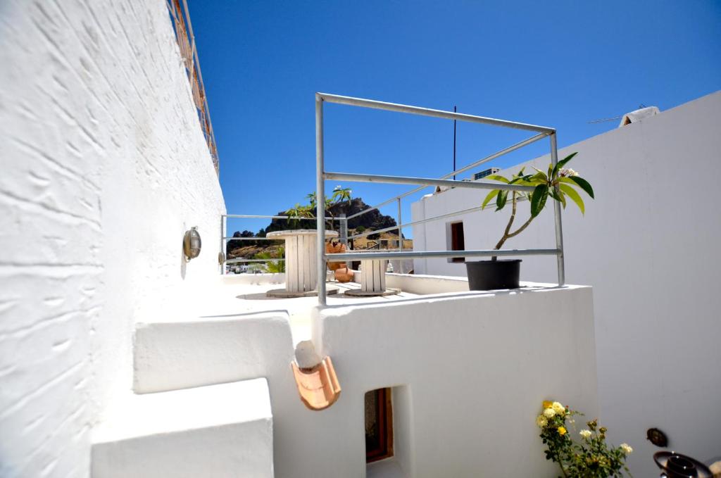 Una casa blanca con una ventana en el costado. en Lindos Esel Suites, en Lindos