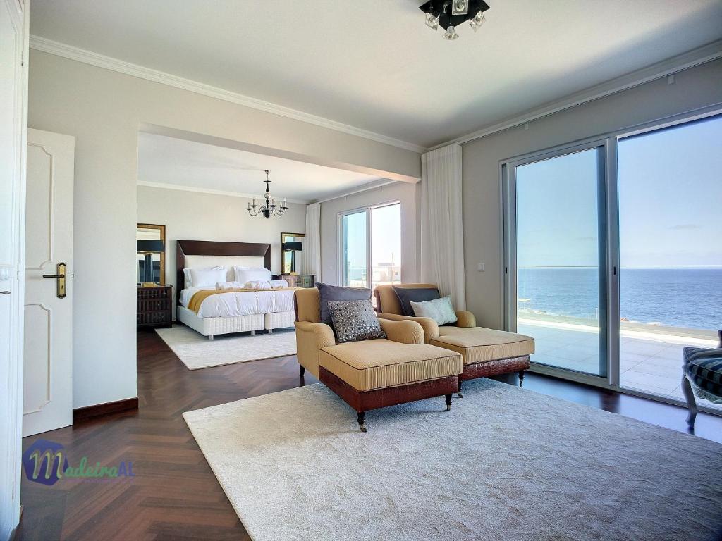 une chambre avec un lit et une chambre avec l'océan dans l'établissement Pearls Beach Villa, à Porto Moniz