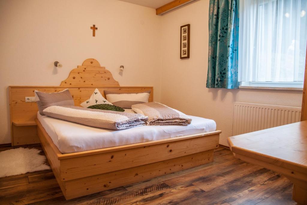 a bedroom with a bed with a cross on the wall at Bauernhof Fuhrmannslochhof in Nauders