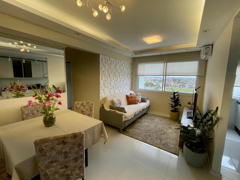 ein Wohnzimmer mit Tisch und Couch in der Unterkunft Apartamento Cond JK Parque Club in Pelotas