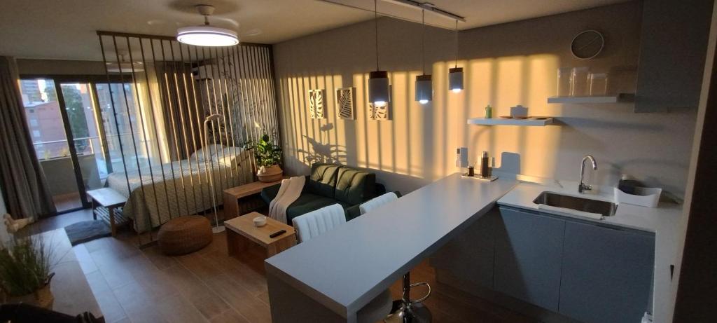 a kitchen and living room with a couch and a sink at Studio Bliss in Neuquén