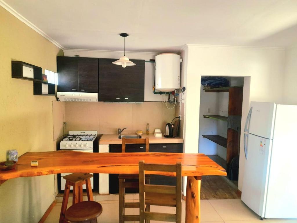 a kitchen with a wooden table and a refrigerator at Casa el sueño de Alicia in Villa del Dique