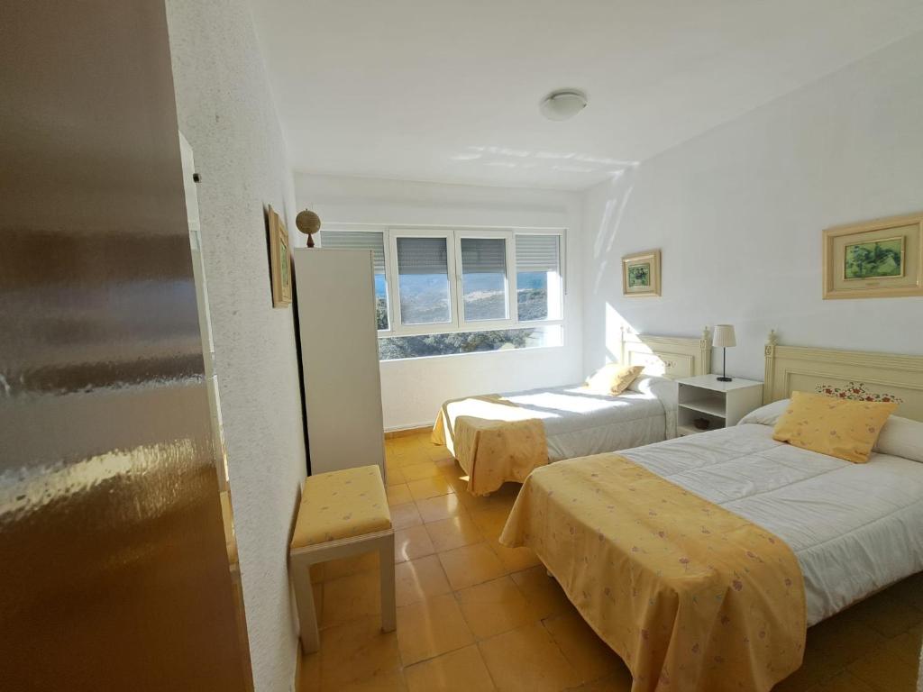 ein Hotelzimmer mit zwei Betten und einem Fenster in der Unterkunft Casa Terra in Hontanar