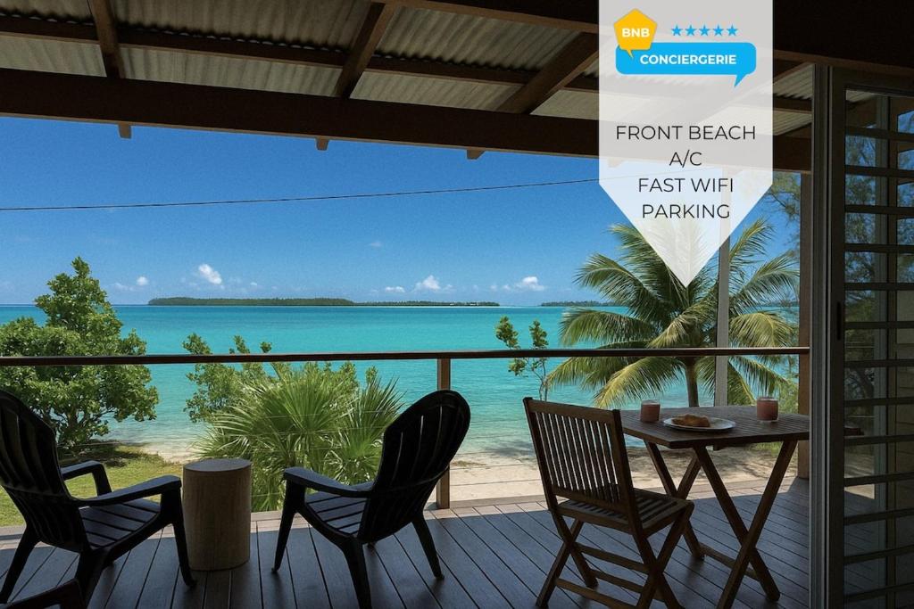 a table and chairs on a deck with a view of the ocean at Studio with a view of a heavenly lagoon in Bora Bora