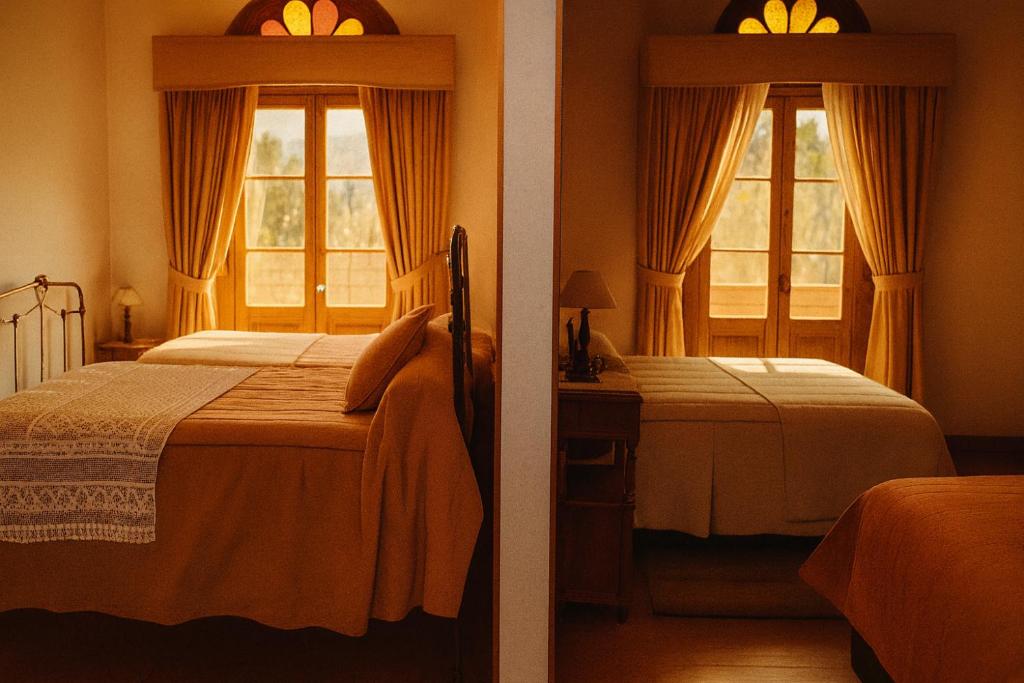 a bedroom with two beds and two windows at Hotel HALLEY & Vive la Magia del Valle de Elqui in Vicuña