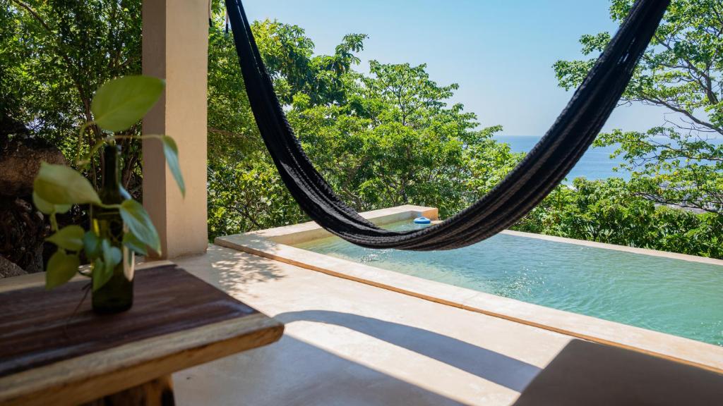 a hammock in a room with a view of the ocean at Casa Gaya in San Pedro Pochutla