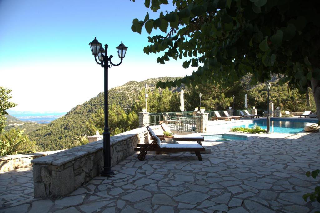 a bench next to a street light next to a pool at Sommer Dafnopanagia Villa Magda in Káto Exánthia