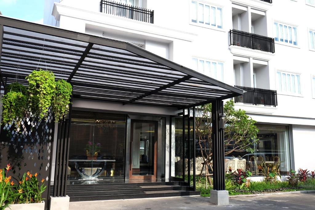 a black pergola in front of a building at Methavalai Residence Hotel in Bangkok