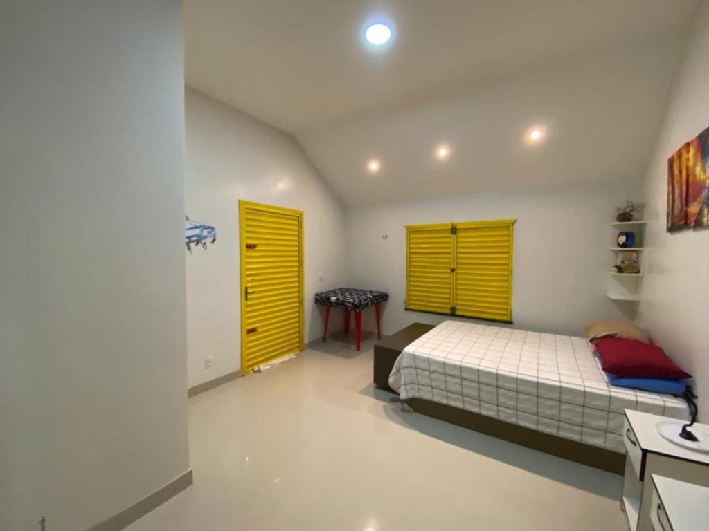una camera da letto con un letto e due porte gialle di Retiro Esperança a Santa Isabel do Pará