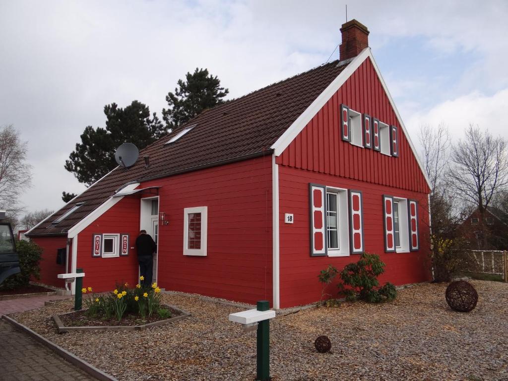 a red house with a black roof at Ferienhaus Achtein in Westoverledingen