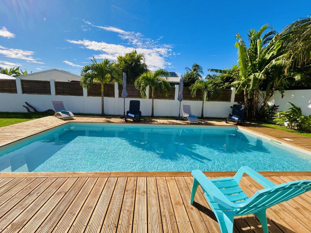 a swimming pool with a deck and a blue chair at Ile en Ile in Saint-François