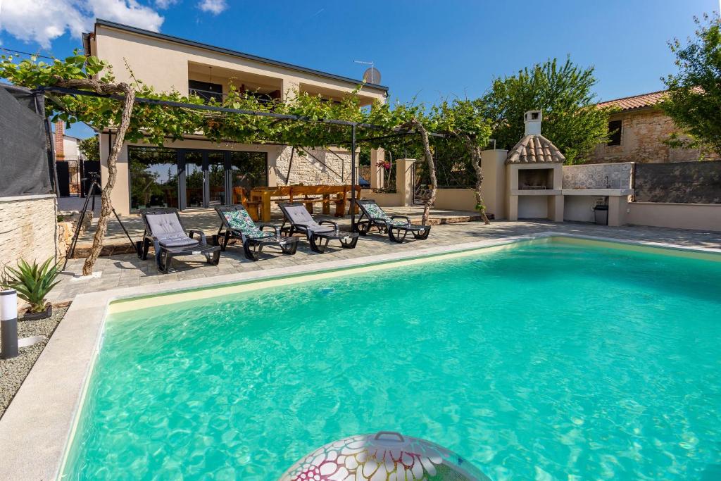 une piscine devant une maison dans l'établissement Schönes Ferienhaus In Modrusani Mit Großem Garten, à Žminj