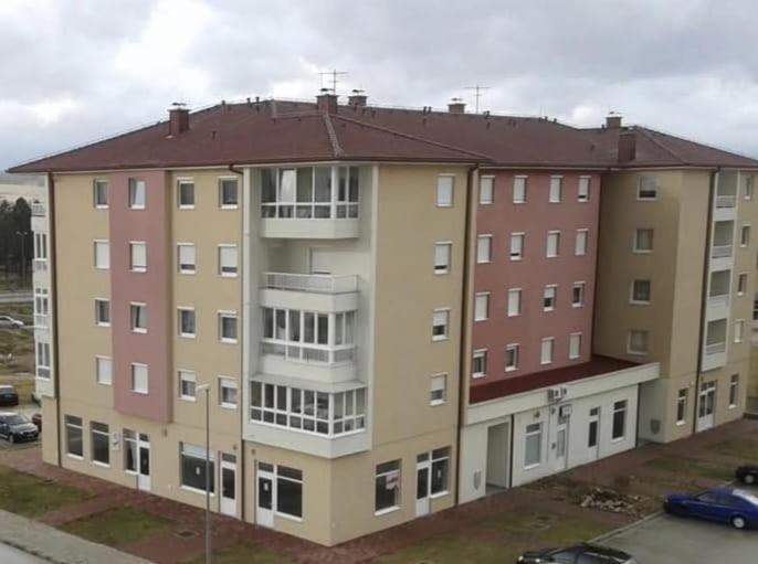 a large apartment building in a parking lot at Livno Sympan in Livno