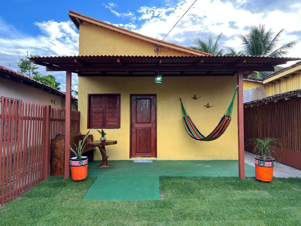 a yellow house with a hammock in front of it at Refúgio Marajoara in Soure