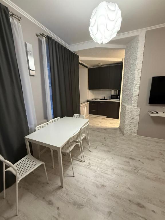 een eetkamer met een witte tafel en stoelen bij Jurges Relax Graza in Daugavpils