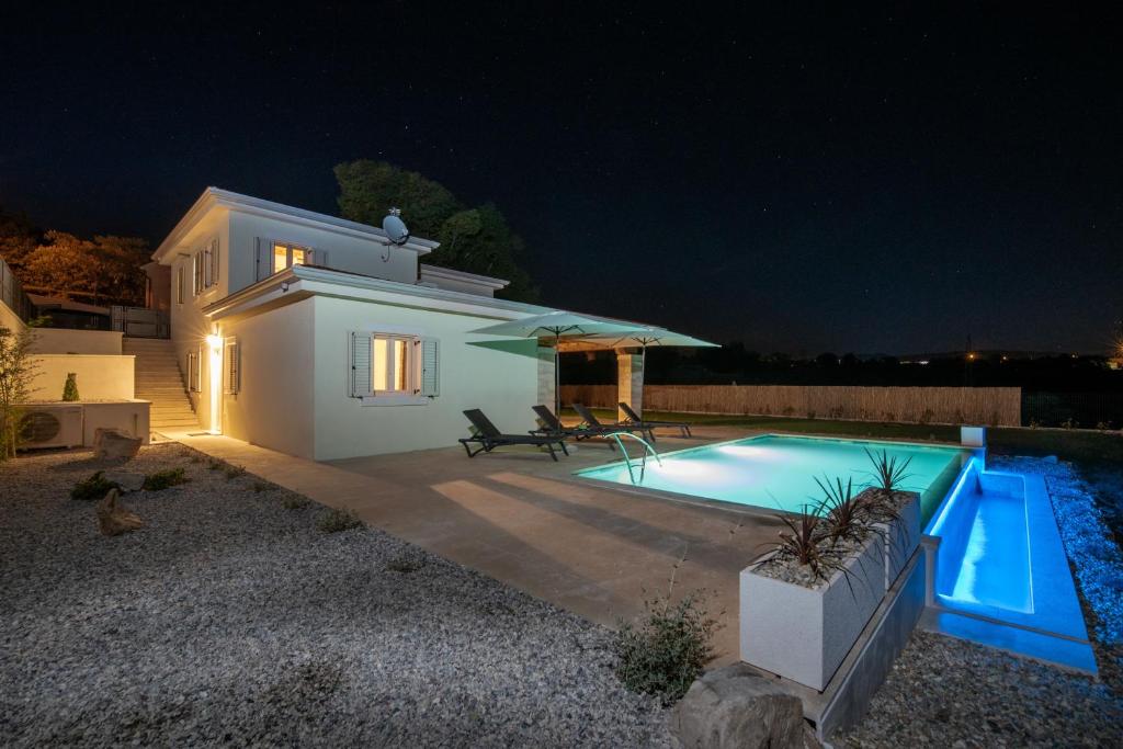 a villa with a swimming pool at night at Villa Tereza in Vinež