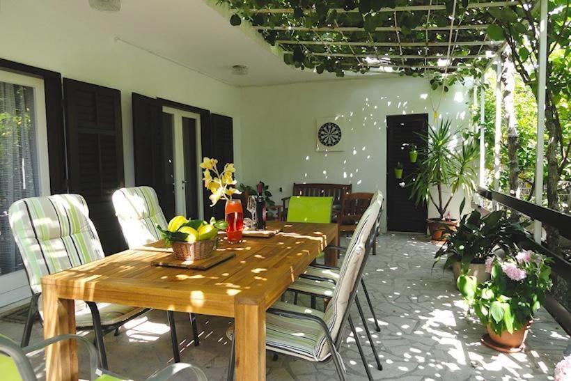 une salle à manger avec une table et des chaises en bois dans l'établissement Ferienhaus Karmen Auf Zwei Ebenen Mit Garten, à Orebić
