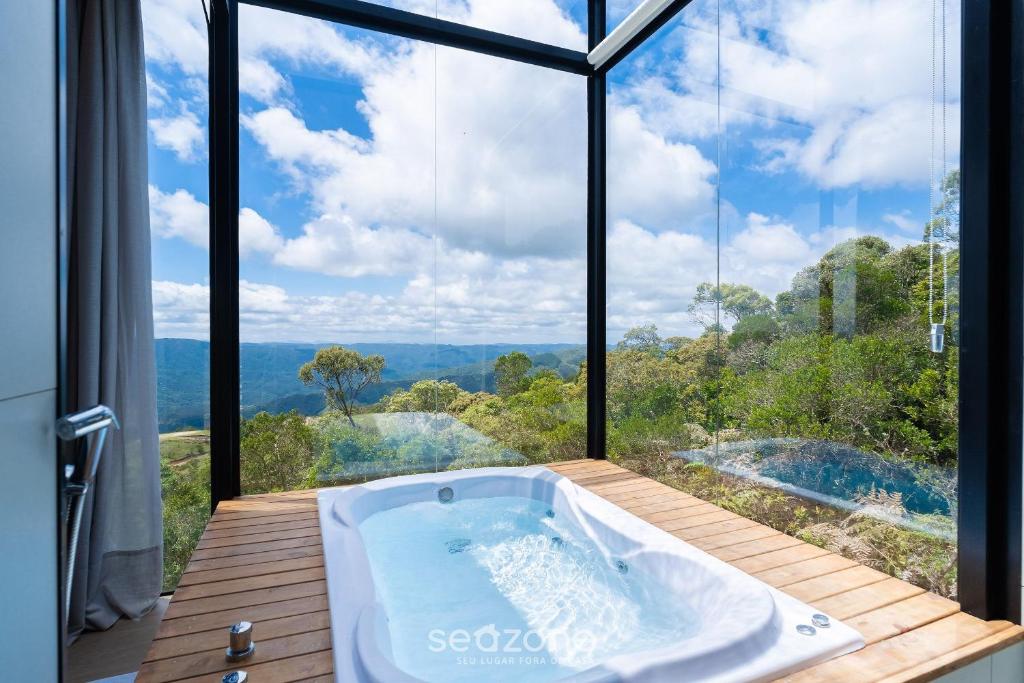 Una bañera en una habitación con una ventana grande. en Cabaña con chimenea e hidromasaje! VST044, en Annitapolis