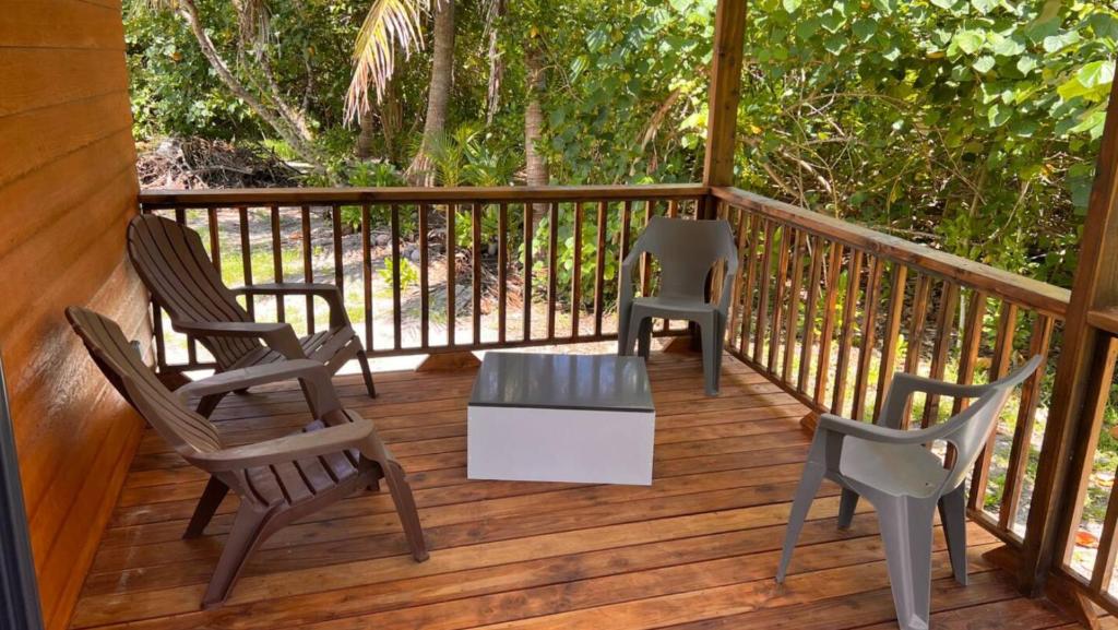 3 sedie e un tavolo su una terrazza di HUAHINE- Fare luna a Parea