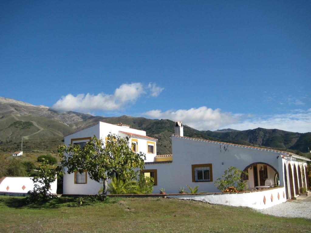 a white house with mountains in the background at Casa Siete Arcos in Sedella