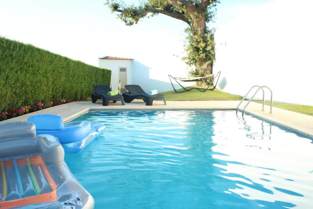 einen Pool mit Stühlen und einer Rutsche im Hinterhof in der Unterkunft Ferienhaus mit Privatpool für 6 Personen ca 290 m in Paradela, Regio Norte Minho in Paradela