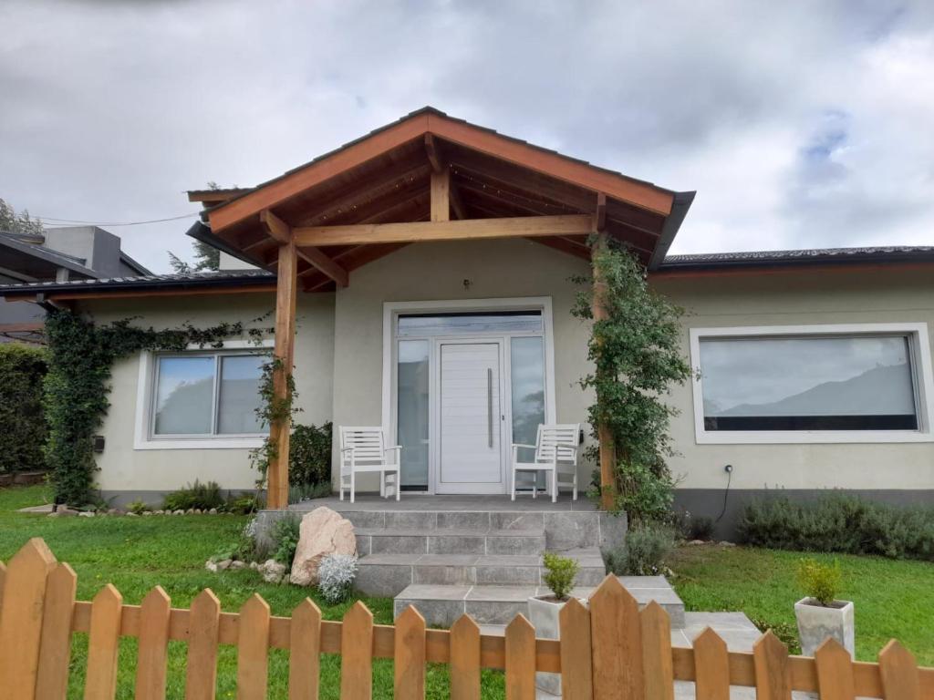 a house with a porch with two chairs on it at Casa con encanto serrano in Villa General Belgrano