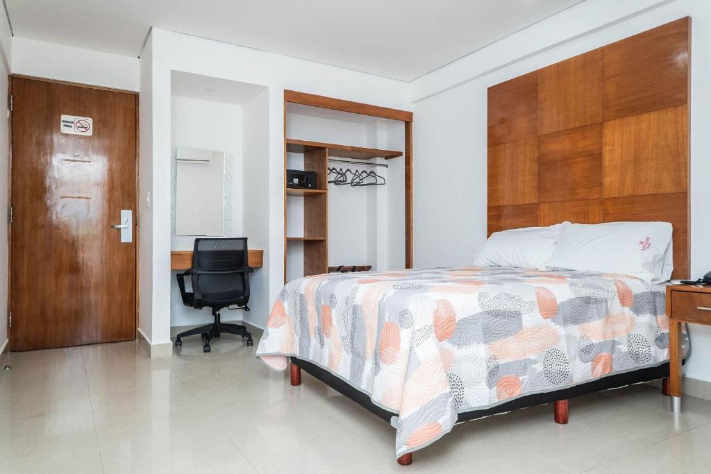 a bedroom with a bed and a desk and a chair at Suites Gaby Cancun in Cancún