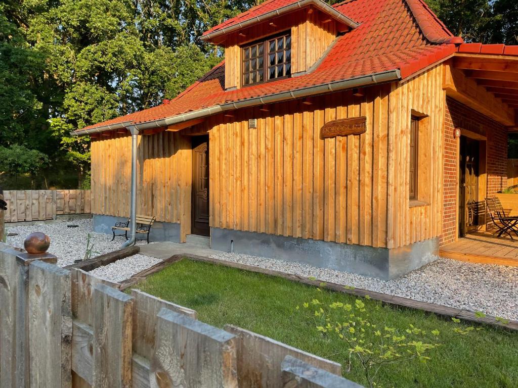 ein Holzhaus mit einem Zaun davor in der Unterkunft Nordstraße 11 Das Ferienhaus in Altwarp