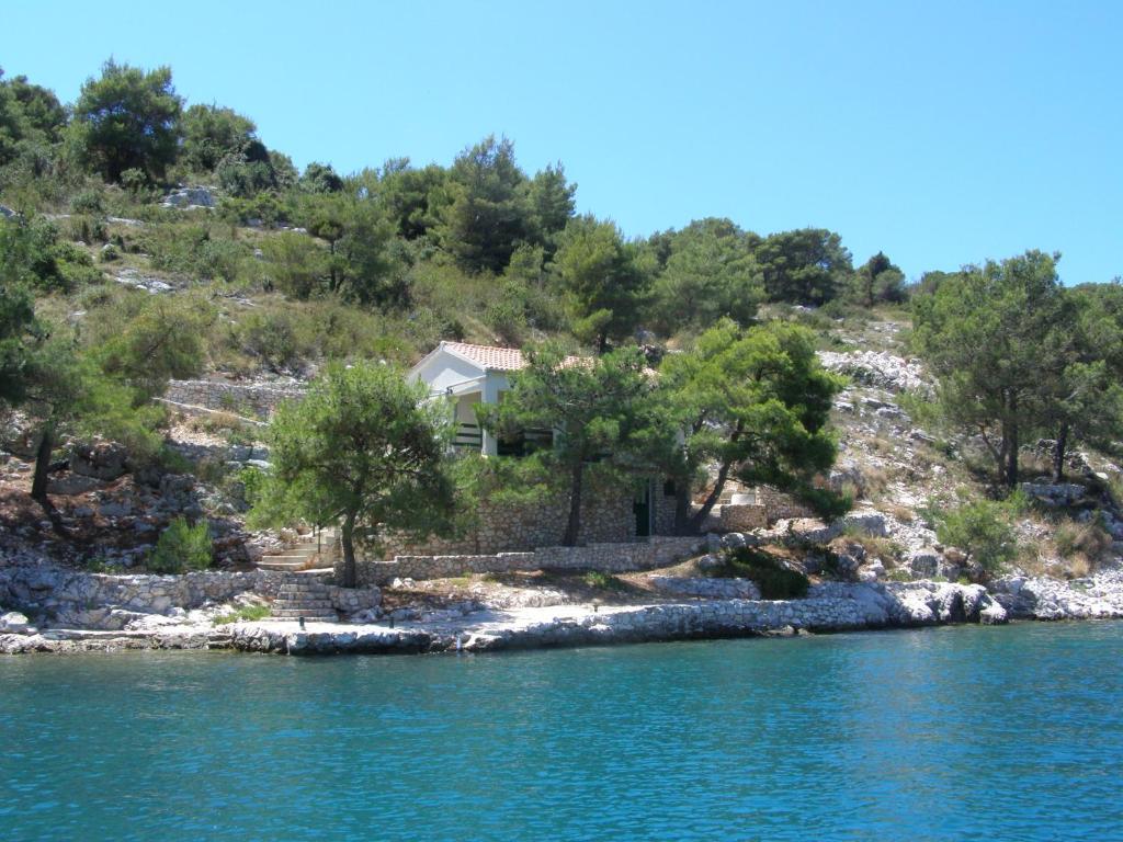 a house on a hill next to the water at Holiday home Dumboka in Sali