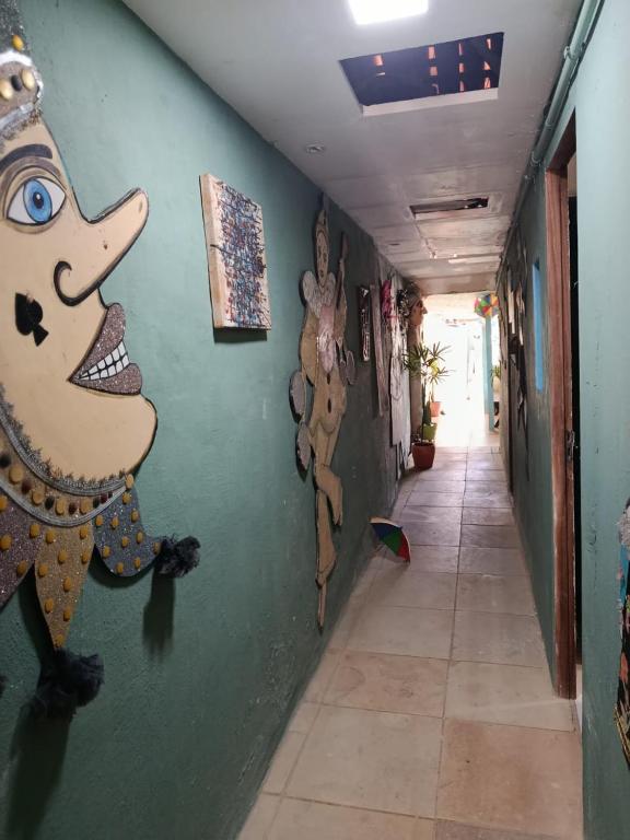 オリンダにあるPousada e Restaurante Morena Raizの廊下の壁に絵が飾られた廊下