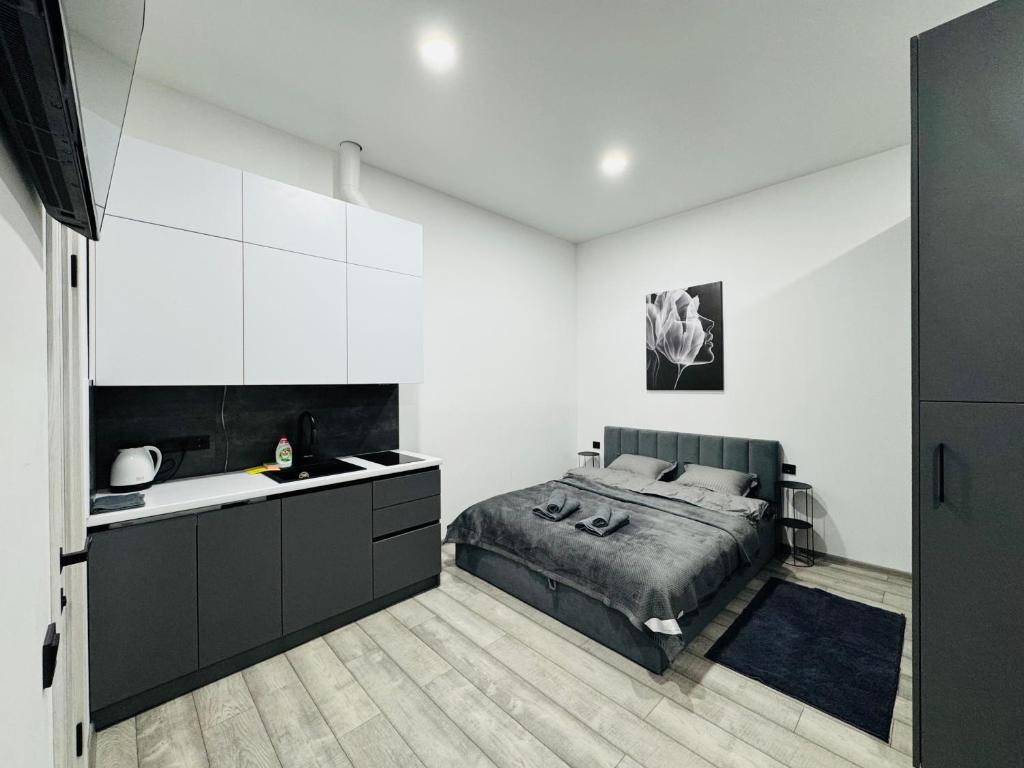 Un dormitorio con una cama y una pared blanca. en Studio Apartment центр міста Чернівці, en Chernivtsi