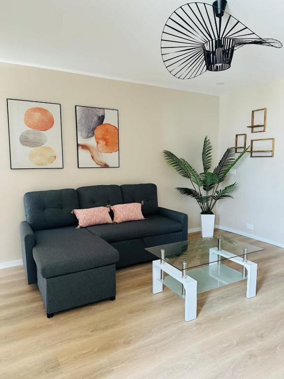 a living room with a blue couch and a glass table at Peaceful Modern HNL Getaway in Honolulu