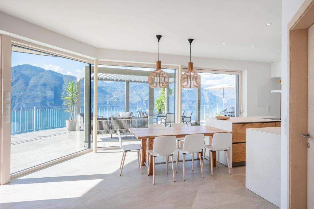 a kitchen and dining room with a table and chairs at Alleinstehende Villa Mit Pool Und Traumaussicht in Castelletto di Brenzone