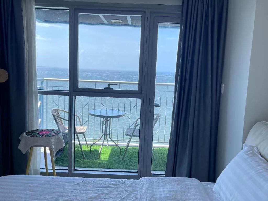 ein Schlafzimmer mit einem Bett und ein Balkon mit einem Tisch in der Unterkunft 95 Sqm Flawless Seaview Luxurious Modern 2 Bedrooms Facing Manila Bay Sunset, Airports, Okada, Solaire, MOA with free parking in Manila