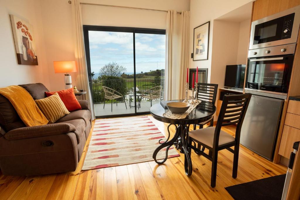 ein Wohnzimmer mit Tisch und Couch in der Unterkunft Ferienhaus für 2 Personen ca 50 qm in Algarvia, Azoren Sao Miguel in Algarvia