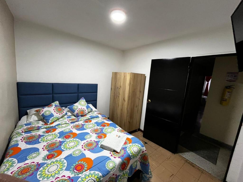 - une chambre avec un lit et un livre dans l'établissement Hotel Inkanta, à Nariño
